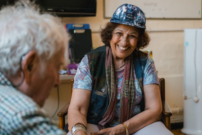 Volunteer smiling at client at dementia club