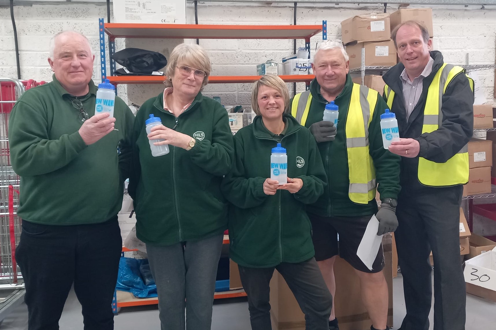 HILS staff standing together and smiling, each holding a Southern Water clear drinking bottle